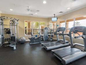 A gym with treadmills, weight machines, and a large exercise ball.