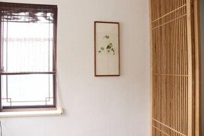 A room with a window, a framed picture on the wall, and a wooden partition. - Shushan Lanting Boutique Hostel (Suzhou)