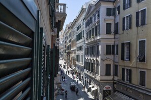 Une rue étroite bordée de bâtiments historiques, agrémentée de balcons et de volets traditionnels.