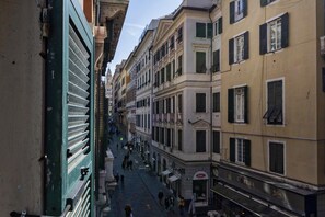 Une rue étroite bordée de bâtiments historiques, qui présente une variété de styles architecturaux et de façades de magasins.