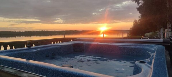 A hot tub with a view of a sunset over a body of water. - ArcticMagic (Tervola)