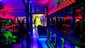 A brightly lit corridor with a central pathway, flanked by seating areas and a bar on the right. - ArcticMagic (Tervola)