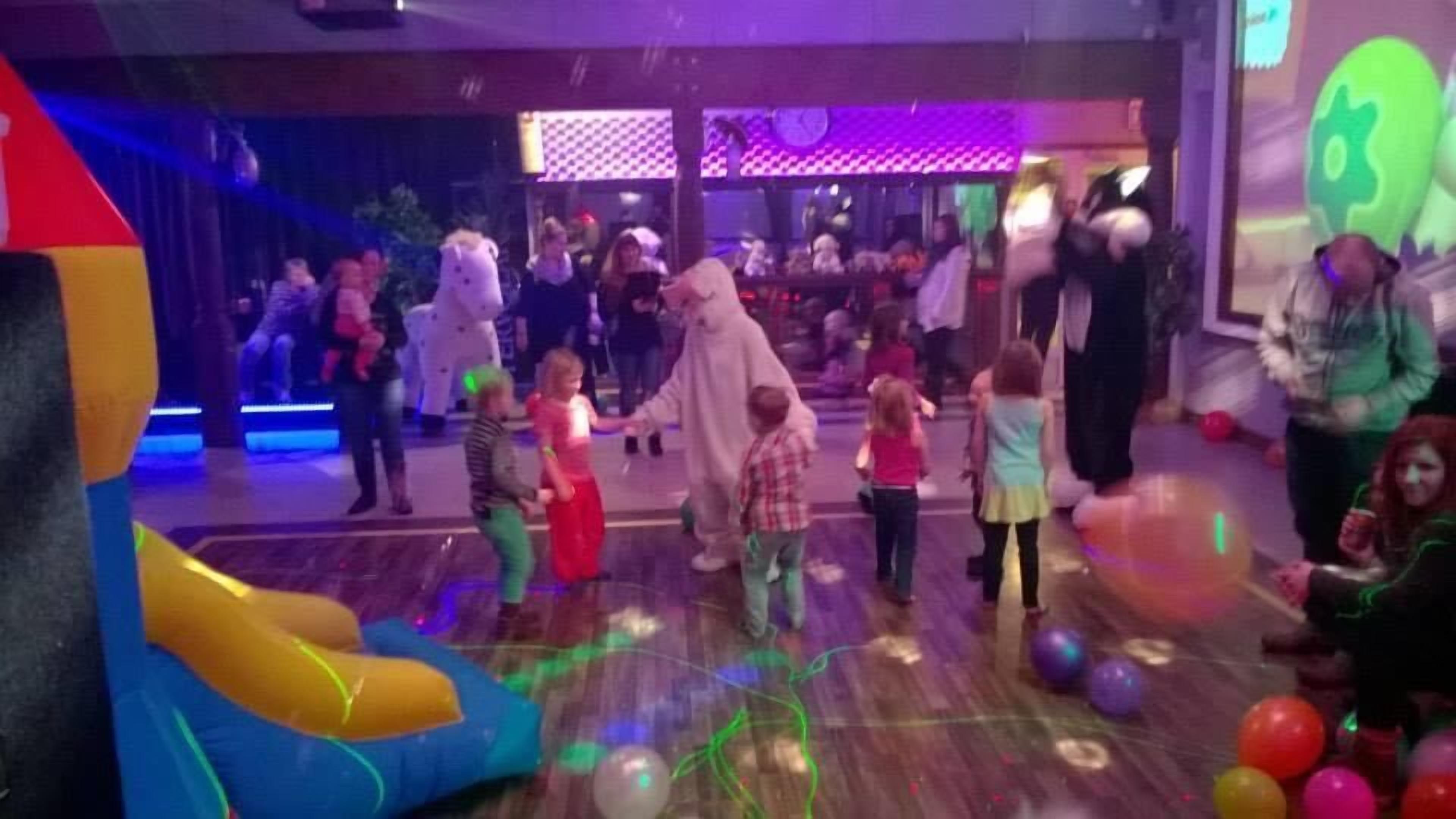 A children's play area with a slide, inflatable toys, and a mascot.