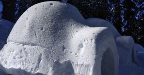 A snow-covered structure with a dome-like top and a flat base.