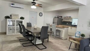 Une cuisine moderne équipée d’un réfrigérateur, d’une cuisinière et d’un évier. On y trouve également un coin repas avec une table et des chaises.