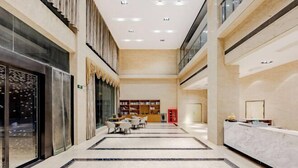 Tilava aula, jossa on vastaanottotiski, oleskelualue ja kirjahylly.