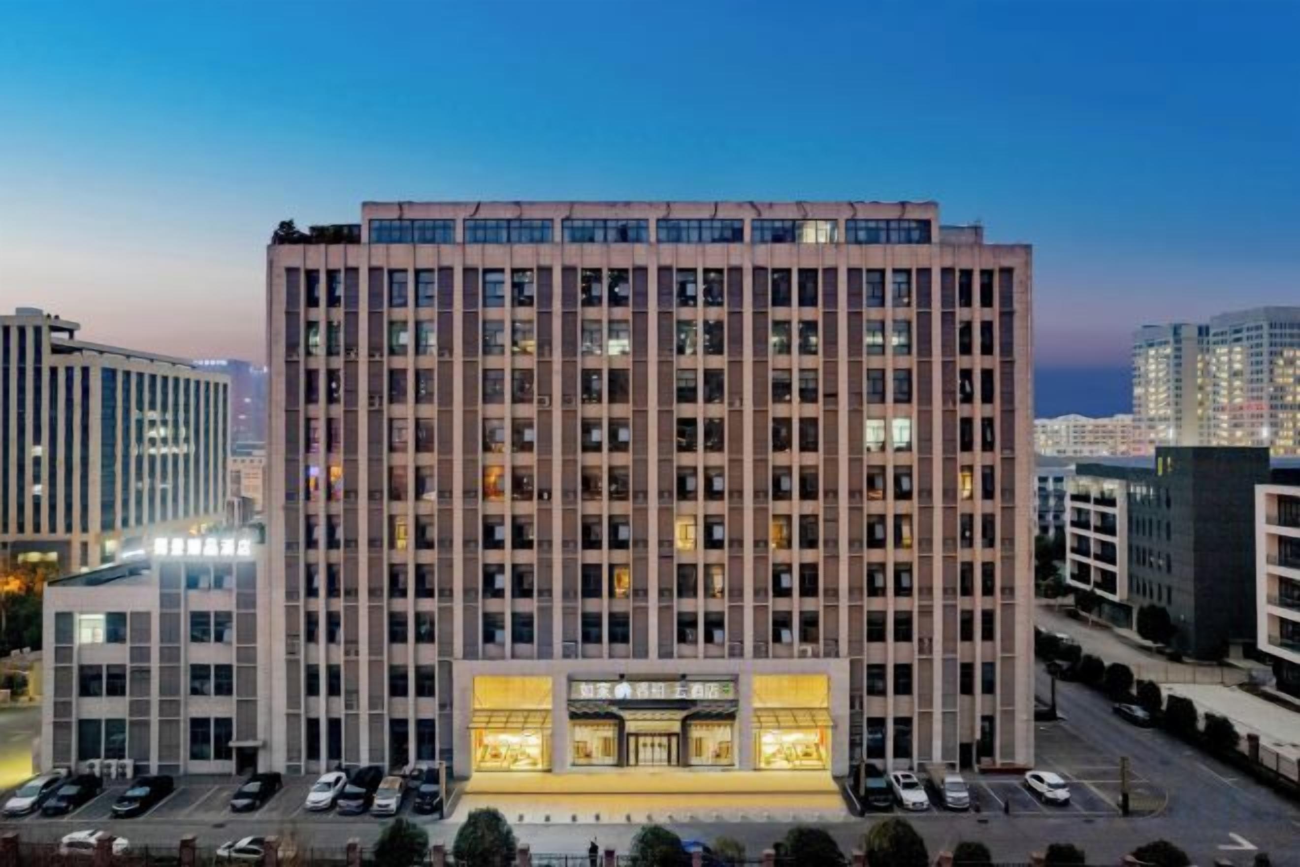 Un hôtel à plusieurs étages, doté d’une entrée principale et d’un parking situé à l’avant.