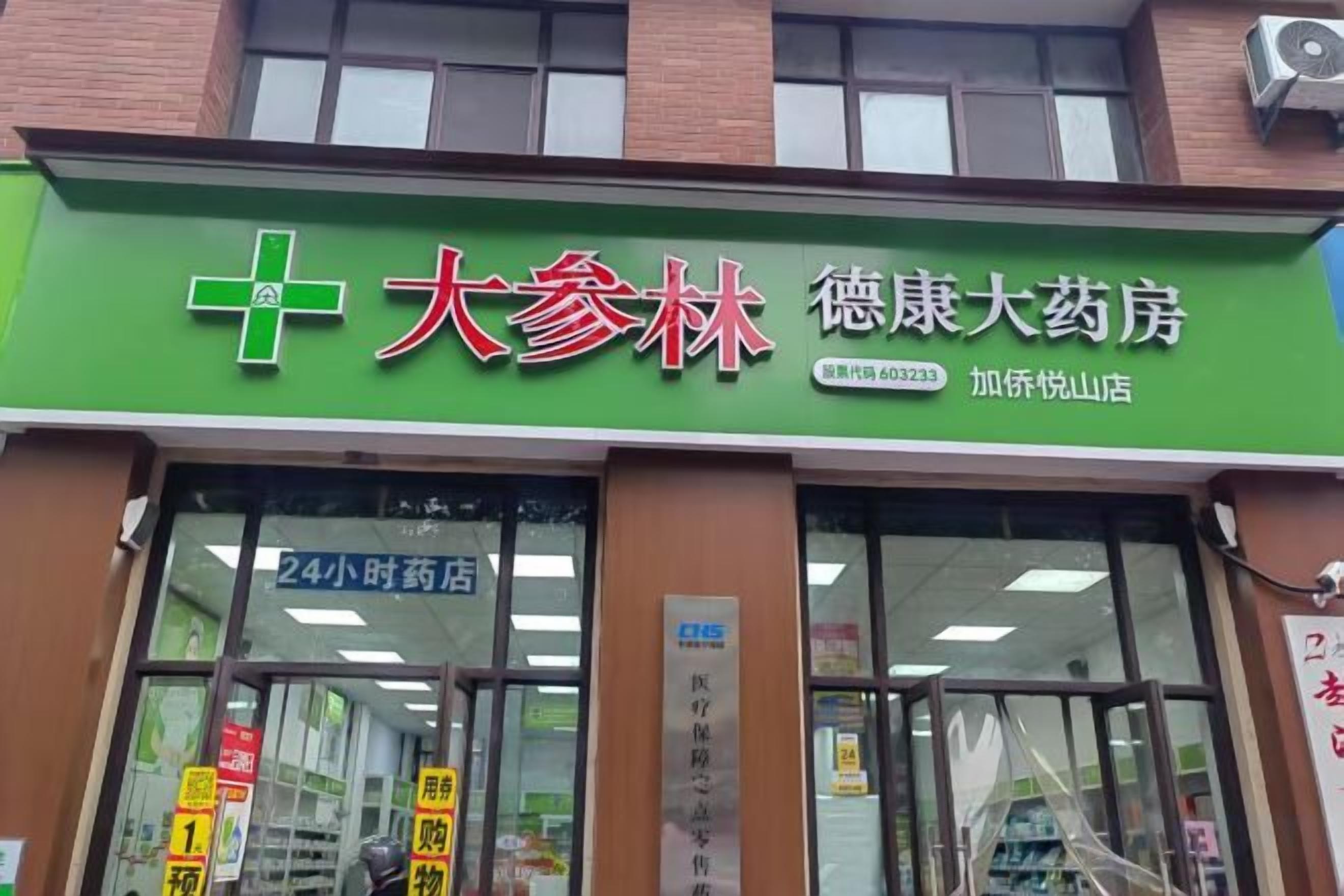 A pharmacy with a green signboard, large windows, and a visible entrance.