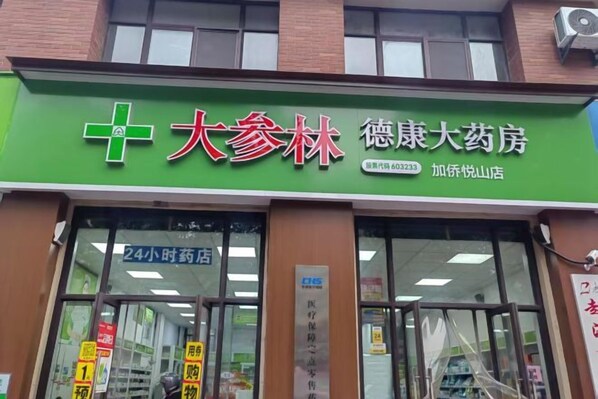 A pharmacy with a green signboard, large windows, and a visible entrance. - Homeinn Ripple Yun Hotel (Hefei Xueji Road) (Hefei)