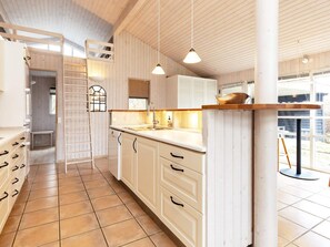 A kitchen with white cabinetry, a tiled floor, and pendant lighting. - 8 Person Holiday Home in Gilleleje (Gilleleje)
