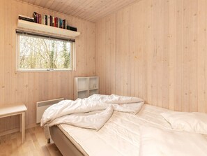 A bedroom with a bed, a window, a bookshelf, and a desk. - 8 Person Holiday Home in Gilleleje (Gilleleje)