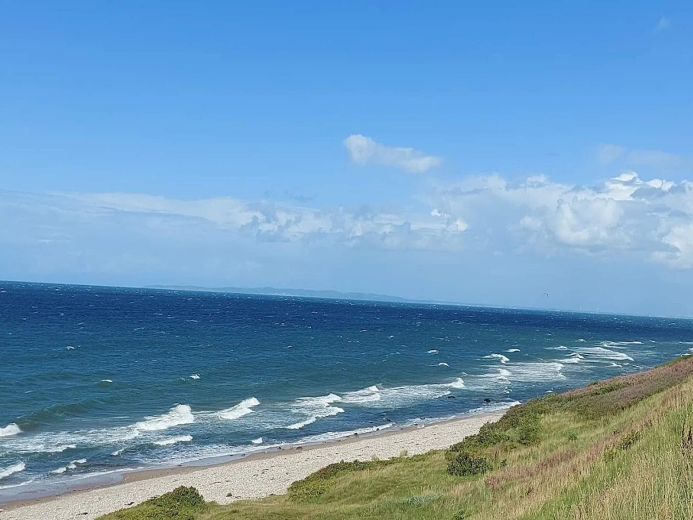A coastal landscape with a beach and ocean.
