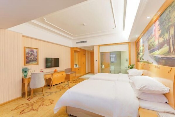 A hotel room with a large bed, a desk with a chair, a television, and a painting on the wall. - Vienna International Hotel (Hubei Province,Huanggang Dongmen Road) (Huanggang)