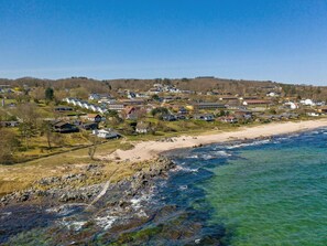 Un área residencial costera con casas, una playa y un litoral rocoso.