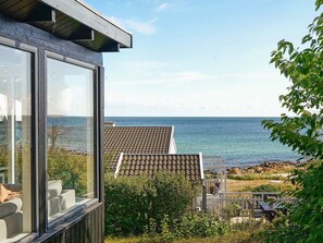 A modern building with large windows overlooking a coastal area. - 4 Star Holiday Home in Allinge (Allinge)