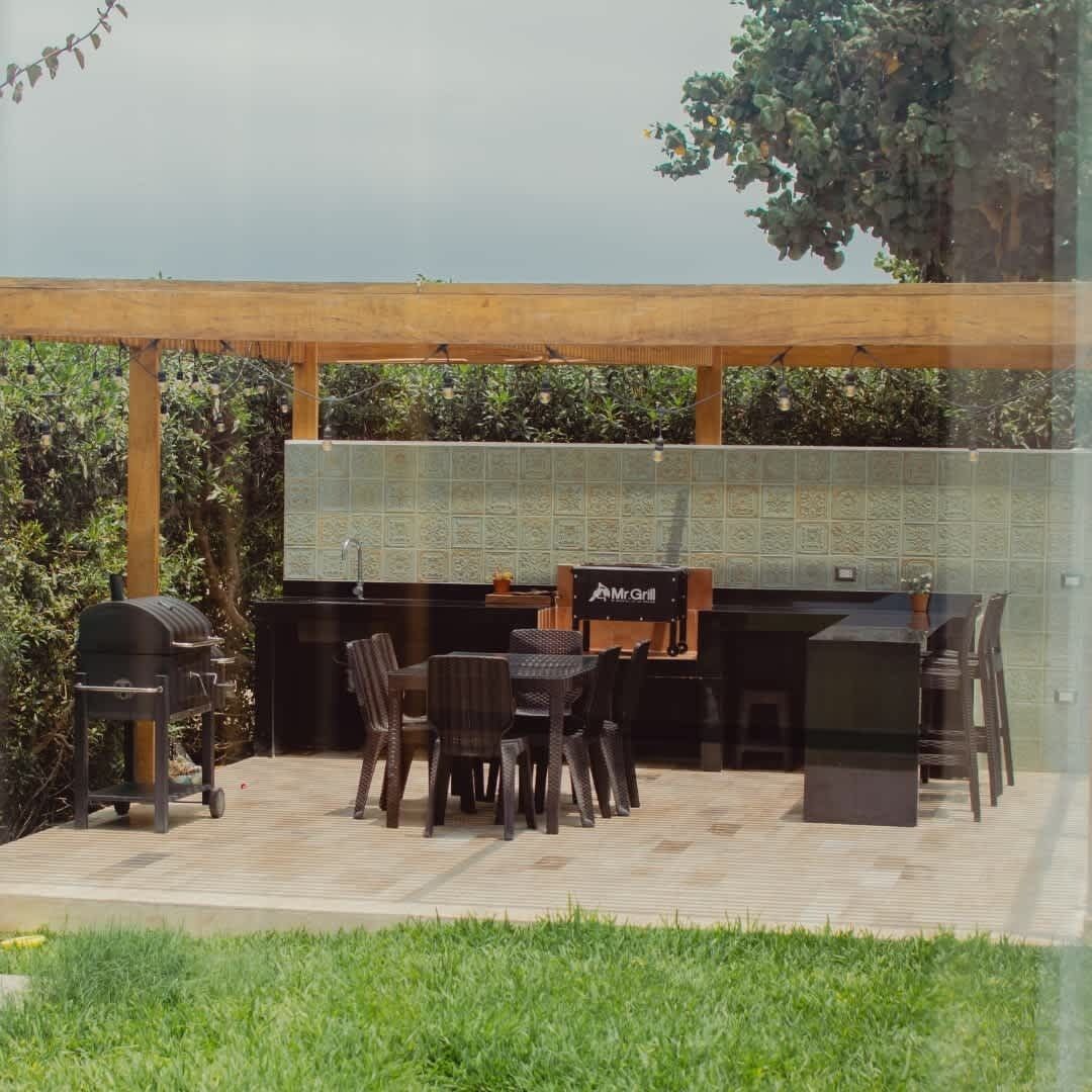 Terrassa exterior amb zona de graella, seients i una façana revestida de rajoles.