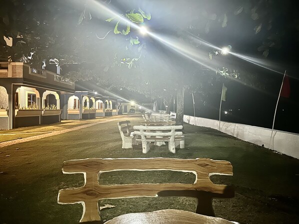 A pathway leading to a building with arched windows and a series of benches. - Emmalyn's Paradise Resort (San Andres)