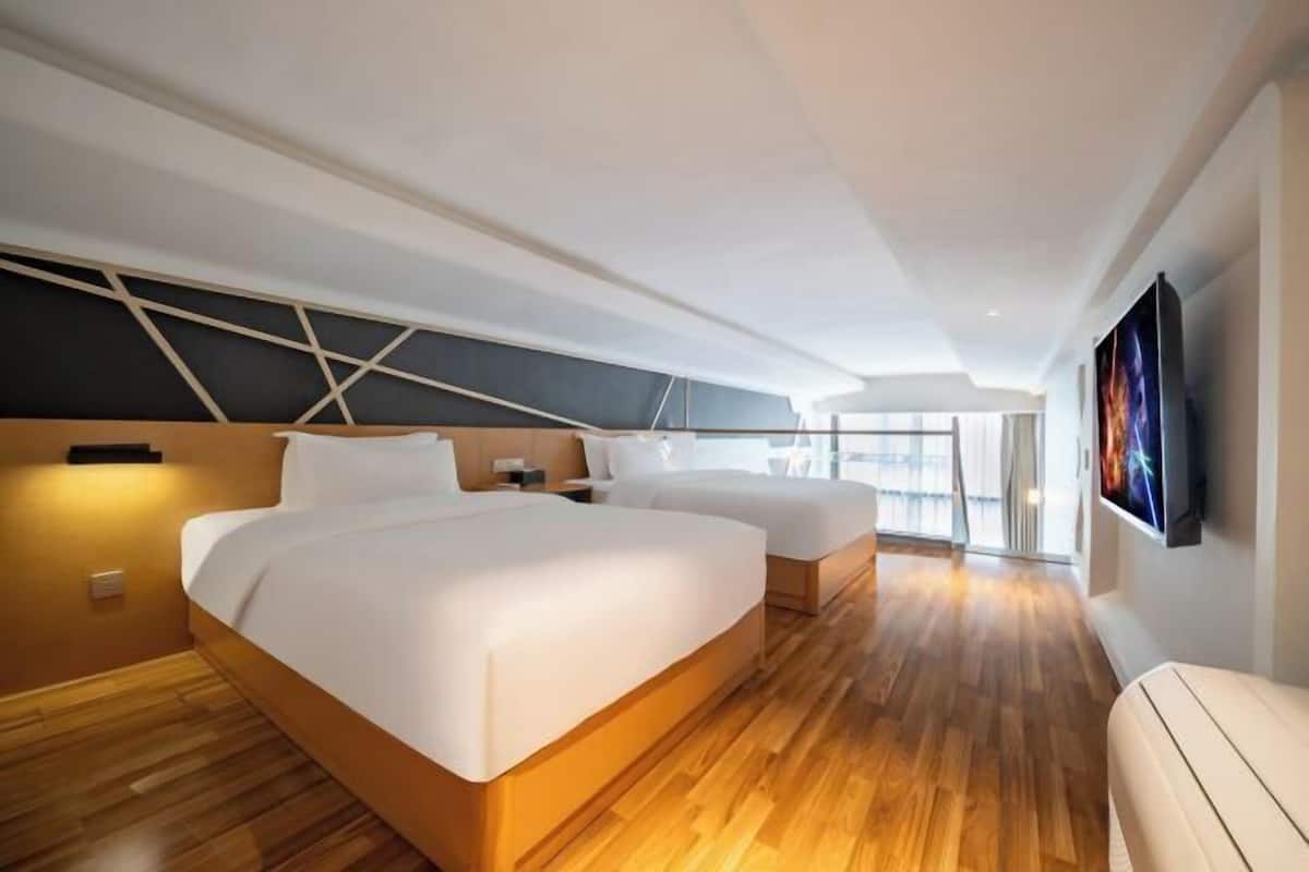 Une chambre d’hôtel moderne avec deux lits, un plancher en bois, une grande fenêtre et un tableau au mur.