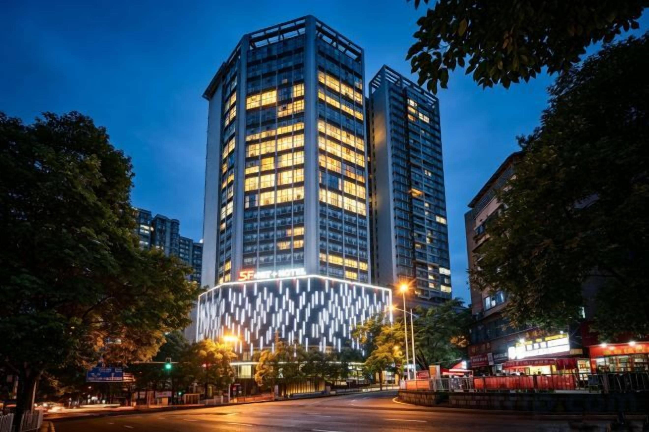 A high-rise building with illuminated windows and a distinctive facade pattern.