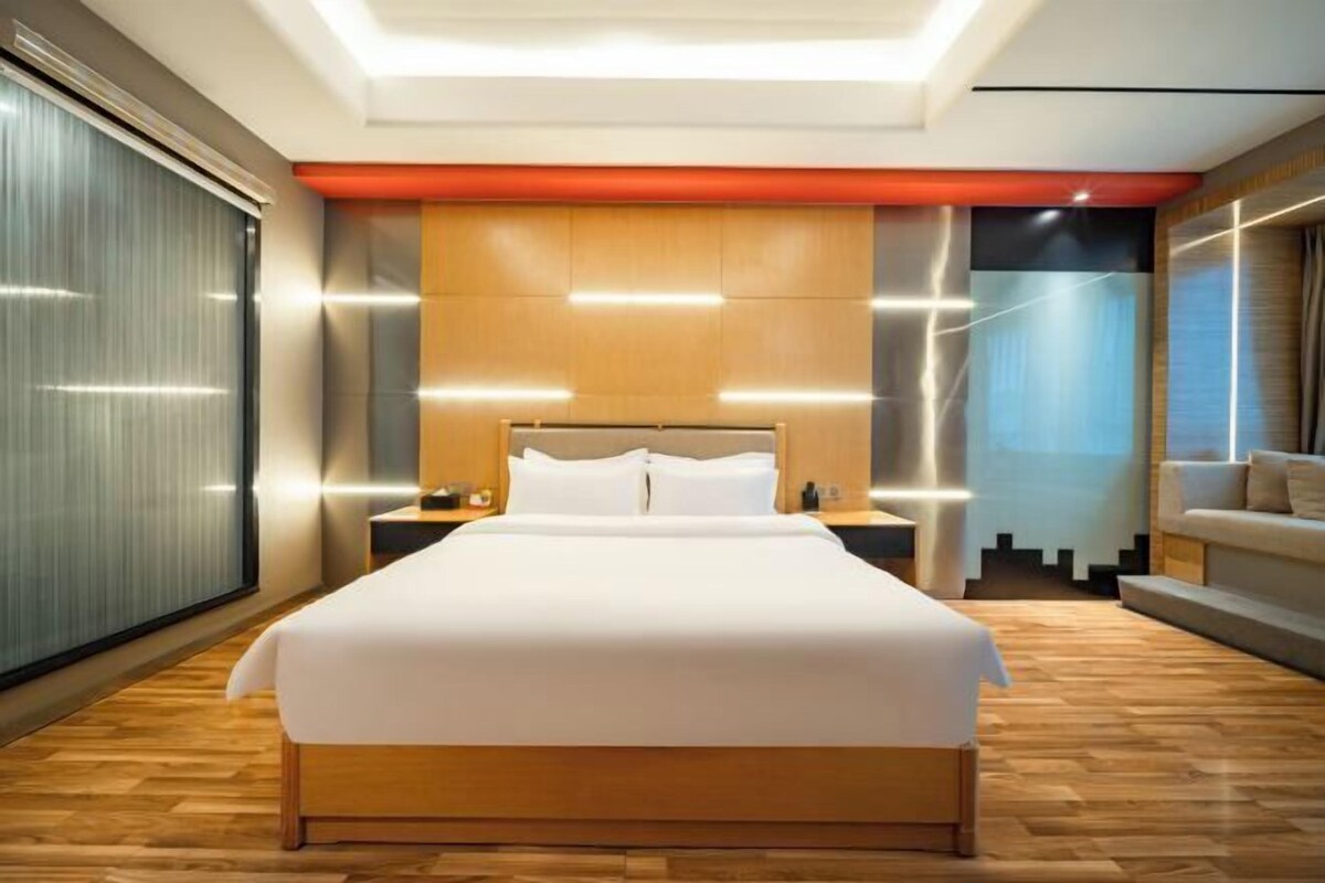 Een moderne slaapkamer met een groot bed, houten hoofdeinde en nachtkastjes.