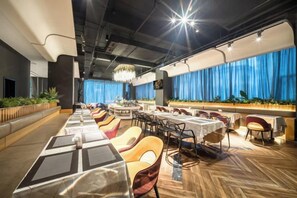Un restaurante moderno con mesas largas compartidas, cabinas individuales y una zona de bar.