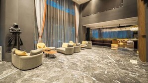 A spacious lobby with a marble floor, large windows with sheer curtains, and modern seating arrangements. - Guiyang Wufang Zhixuan Hotel (Guiyang)