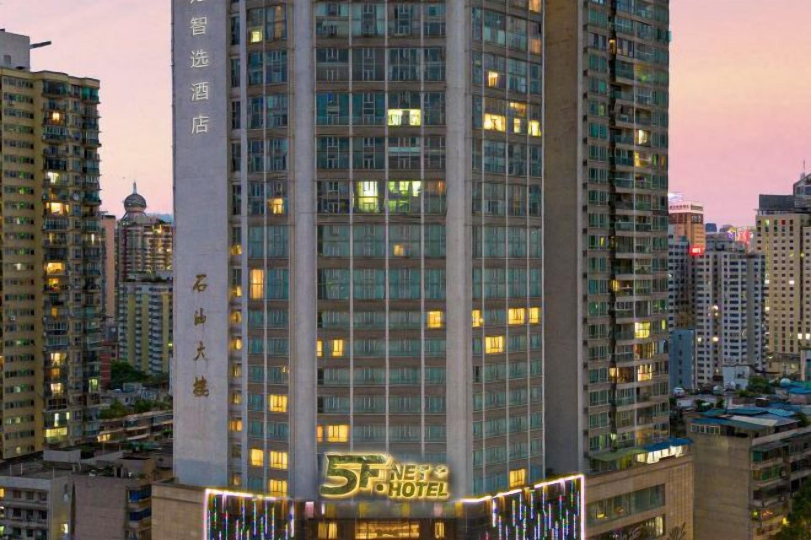 A high-rise hotel with multiple floors, large windows, and a prominent sign at the bottom.