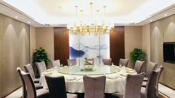 A conference room with a round table, chairs, and a chandelier.