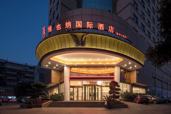 A hotel with a prominent entrance, a circular design, and a sign with Chinese characters.