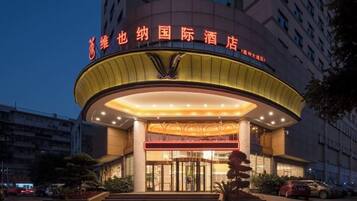 A hotel with a prominent entrance, a circular design, and a sign with Chinese characters.