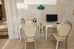 A room with two ornate chairs, a desk with a computer, and a sign on the wall. - Vienna International Hotel (Wenzhou Avenue Railway Store) (Wenzhou)