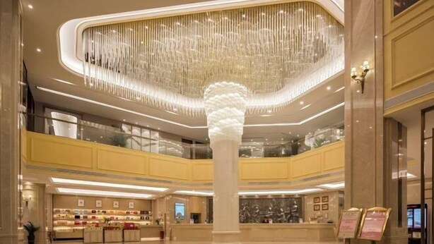 A spacious lobby with a central column, a chandelier, and a reception desk. - Vienna International Hotel (Wenzhou Avenue Railway Store) (Wenzhou)