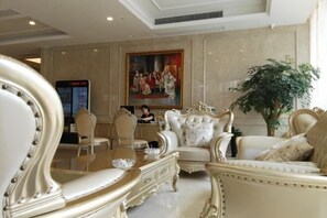 A luxurious lobby with ornate furniture, a large painting, and a digital information board. - Vienna International Hotel (Wenzhou Avenue Railway Store) (Wenzhou)