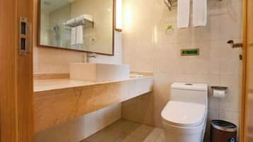 Uma casa de banho moderna com lavatório de mármore, sanita e zona de duche.