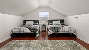 A bedroom with two beds, a window, and a ceiling light. - Large Fenced Yard and Outdoor Patio (Lewiston)