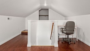 A room with a sloped ceiling, a desk with a chair, and a wooden ladder leaning against the wall. - Large Fenced Yard and Outdoor Patio (Lewiston)