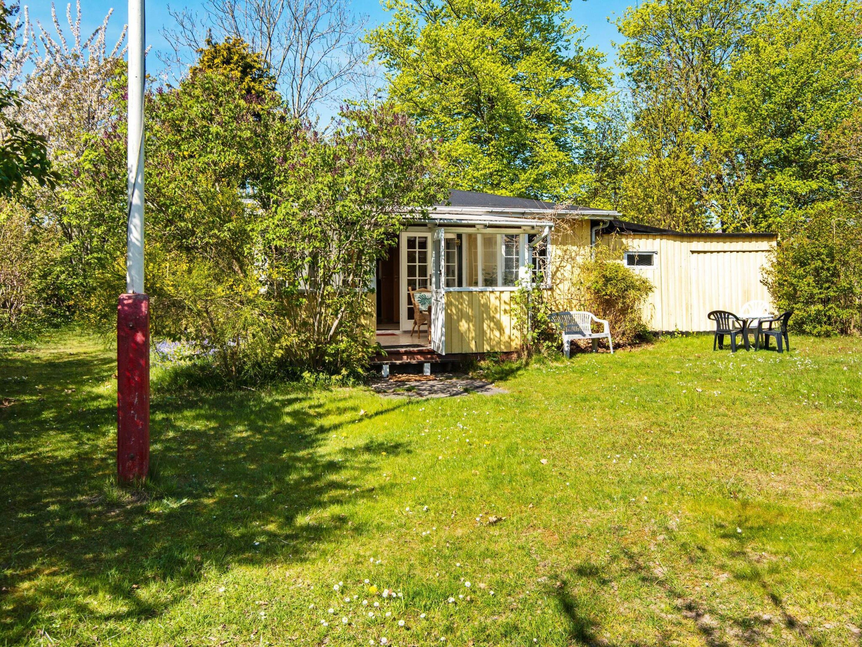 A small house with a porch, a garden, and a shed.