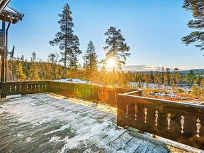 A wooden deck with a railing overlooking a snowy landscape with trees and mountains in the distance. - 4 Star Holiday Home in Veggli (Rollag)