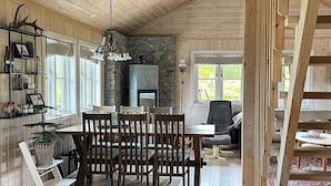 A cozy dining area with wooden furniture, a stone fireplace, and a view of the outdoors. - 4 Star Holiday Home in Veggli (Rollag)