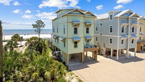 A beachfront property with multiple buildings, including a large house with a balcony and a smaller structure with a covered porch. - Money Beach: Private Pool, 7 Bedrooms, Sleeps 25! (Indian Pass)