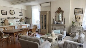 A spacious living room with a dining area, a kitchen, and a cozy seating area with a fireplace.