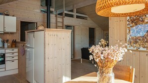 A wooden interior with a kitchen, dining area, and a staircase. - 6 Person Holiday Home in Ringkobing-by Traum (Ringkobing)