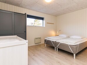 A bedroom with two beds, a window, a heater, and a crib. - 12 Person Holiday Home in Albaek (Aalbaek)