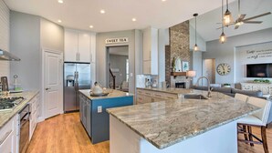 A modern kitchen with a central island, built-in appliances, and a sign reading "SWEET TEA". - Waterfront Lake Tawakoni Home w/ Fire Pit! (Quinlan)