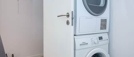 Vue de face d’un appareil combiné lave-linge et sèche-linge, avec un panneau de commande et une poignée de porte.