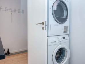 A front view of a stacked washer and dryer unit with a control panel and a door handle. - 5 Person Holiday Home in Ansager (Ansager)