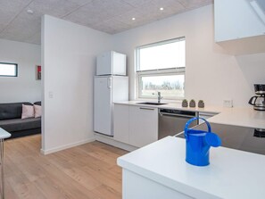 Une cuisine moderne équipée d’un réfrigérateur, d’un lave-vaisselle et d’une fenêtre offrant une belle vue.