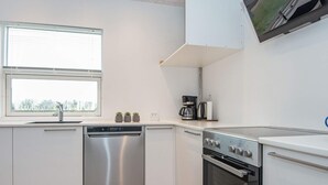 A modern kitchen with stainless steel appliances, a dishwasher, and a coffee maker. - 5 Person Holiday Home in Ansager (Ansager)