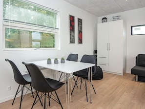 A modern meeting room with a white table, black chairs, and potted plants. - 5 Person Holiday Home in Ansager (Ansager)