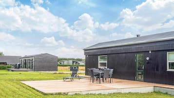 A modern building with a patio area featuring outdoor furniture.